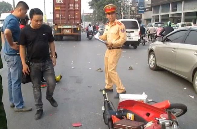 Ha Noi: 2 nguoi ngoi xe may bi cuon vao gam container sau va cham - Hinh anh 1