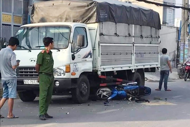 Mat lai sau khi bi giat dien thoai tren duong, 2 cha con  lao xe may vao gam o to tai - Hinh anh 1