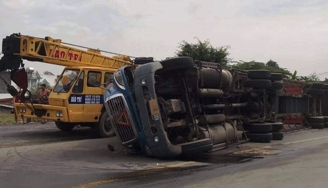 Tai nan giao thong moi nhat hom nay 1/12: Xe container lat ngang duong, tai xe mac ket trong cabin - Hinh anh 1