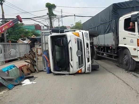 Xe tai cho sat vun lat o Cau Lon, nhieu nguoi la het bo chay - Hinh anh 1