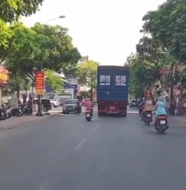 Nguoi phu nu vuot au nga truoc dau xe container - Hinh anh 1