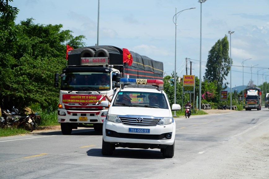 CSGT Quang Ngai ho tro com, nuoc mien phi cho doan xe cuu tro mien Bac - Hinh anh 1