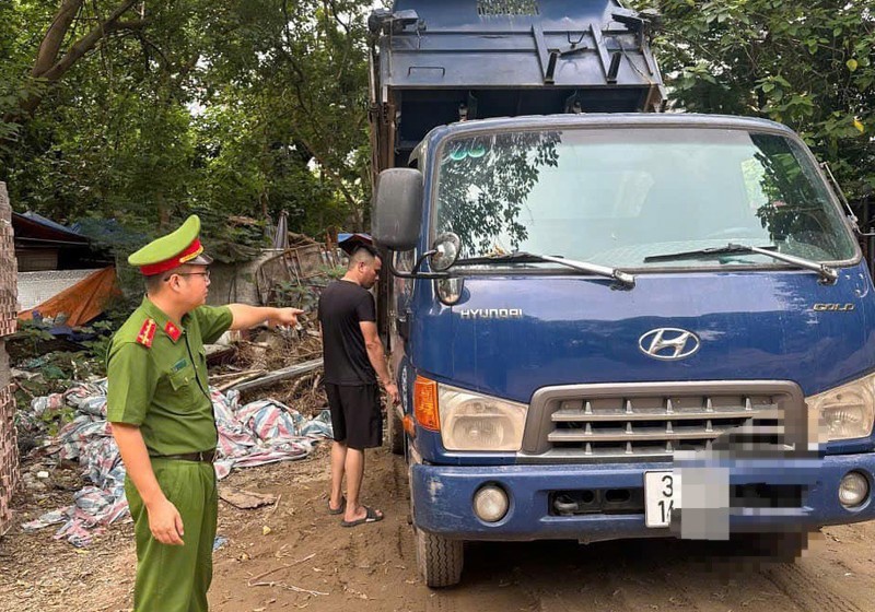 Tai xe xe tai dang do trom phe thai ra moi truong gap ngay canh sat - Hinh anh 1