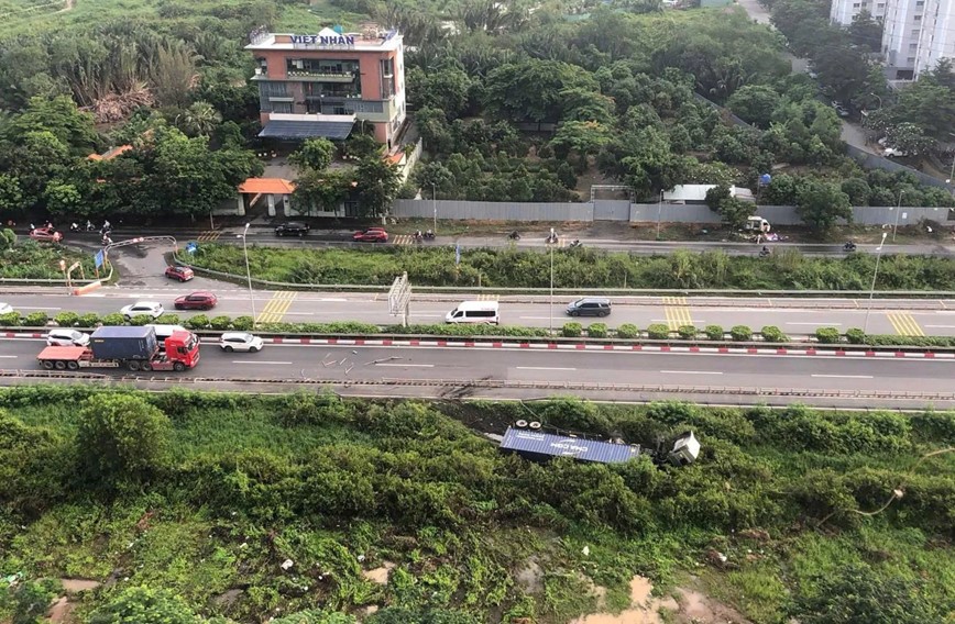 Tai xe buon ngu khien xe container lat nhao tren duong dan cao toc o TP Ho Chi Minh - Hinh anh 1