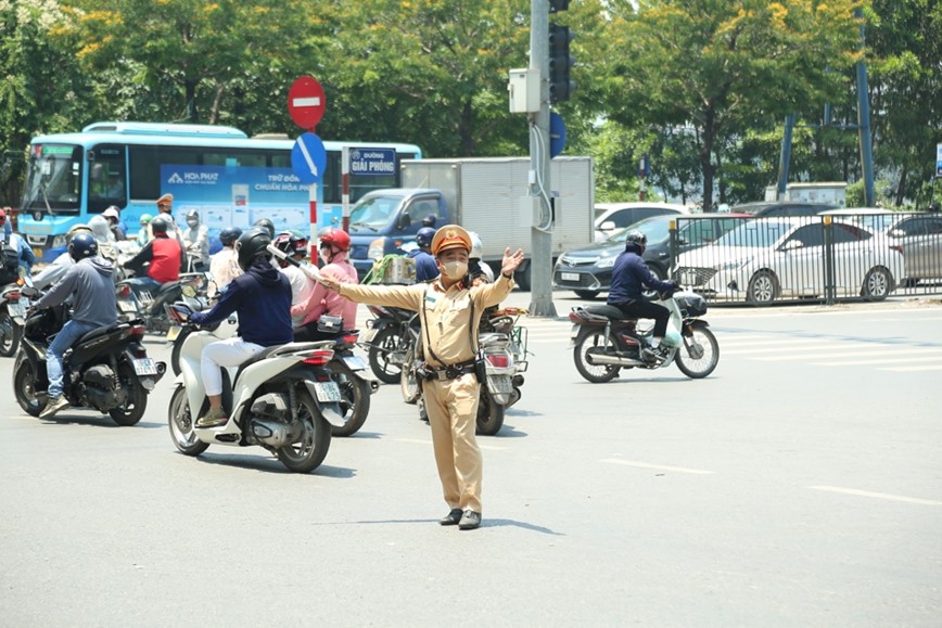 Canh sat giao thong “doi nang” phan luong, huong dan nguoi dan ve que nghi le - Hinh anh 1