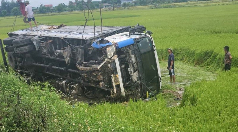 No luc giai cuu xe tai bi lat nghieng duoi ruong lua - Hinh anh 1